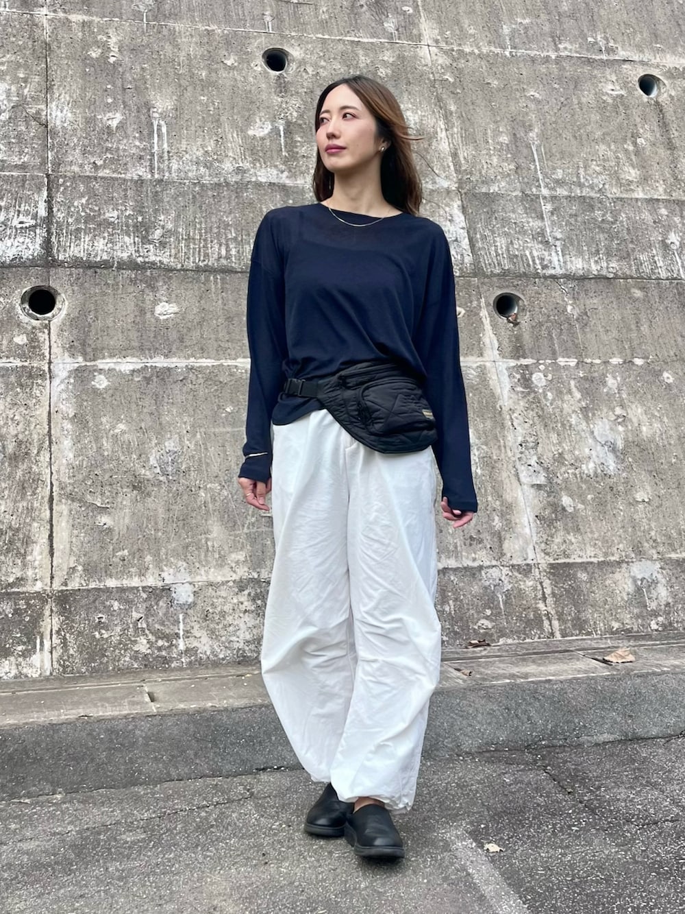 ブルー系のTシャツ/カットソー、ブラック系のスニーカー、ブラック系のボディバッグ/ウエストポーチを着用したレディースの秋コーディネートの3枚目の写真