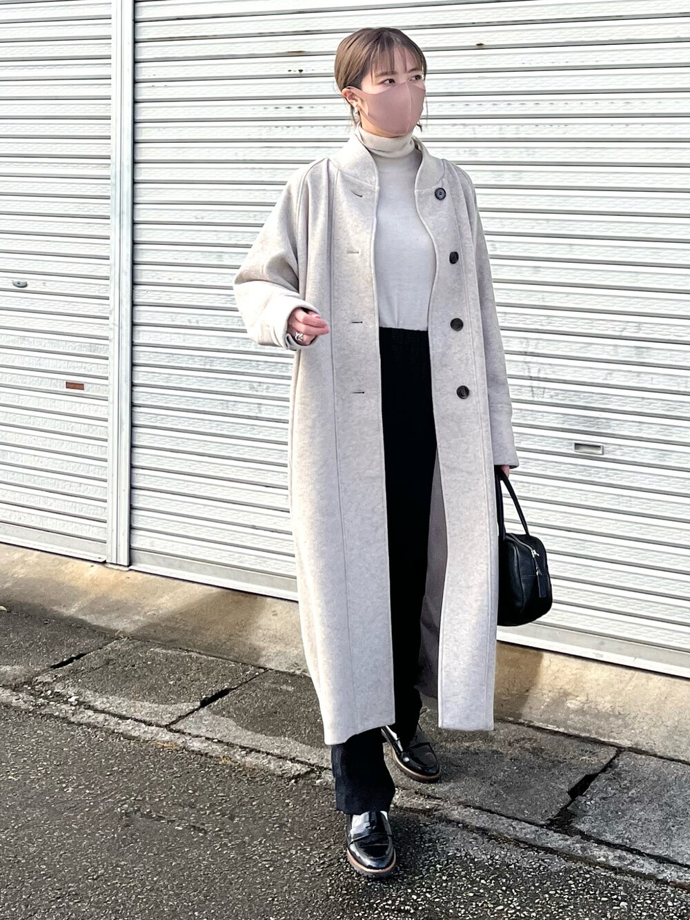 ベージュ系のチェスターコート、オレンジ系のマフラーを着用したレディースの冬コーディネートの2枚目の写真