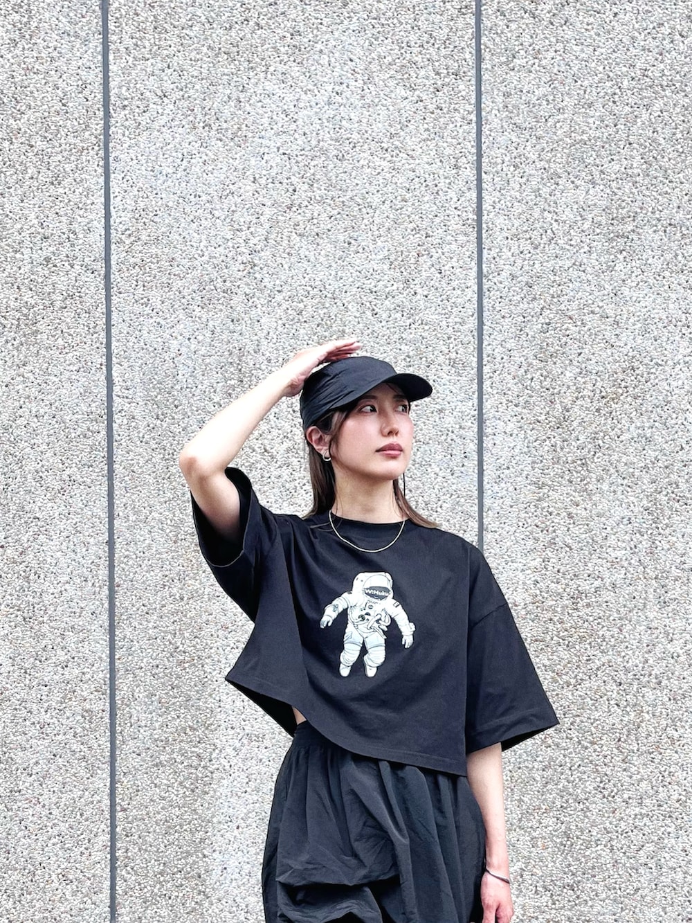ブラック系のTシャツ/カットソー、ブラック系のスカート、ブラック系のスニーカーを着用したレディースの春コーディネートの2枚目の写真
