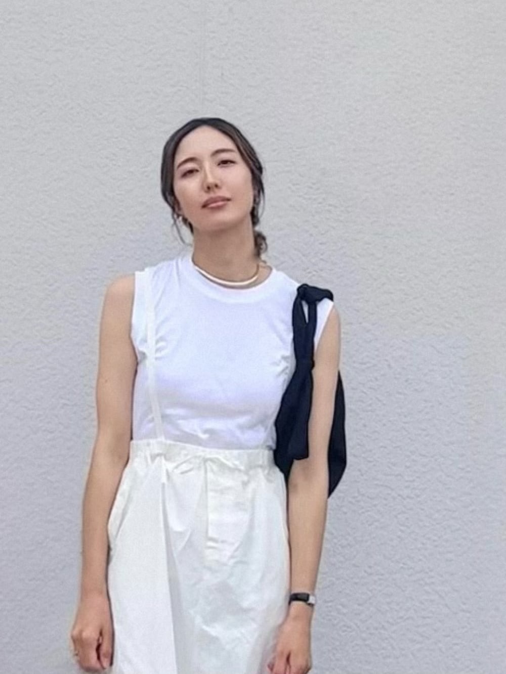 ホワイト系のスカート、ブラック系のTシャツ/カットソー、ホワイト系のサンダルを着用したレディースの夏コーディネートの2枚目の写真