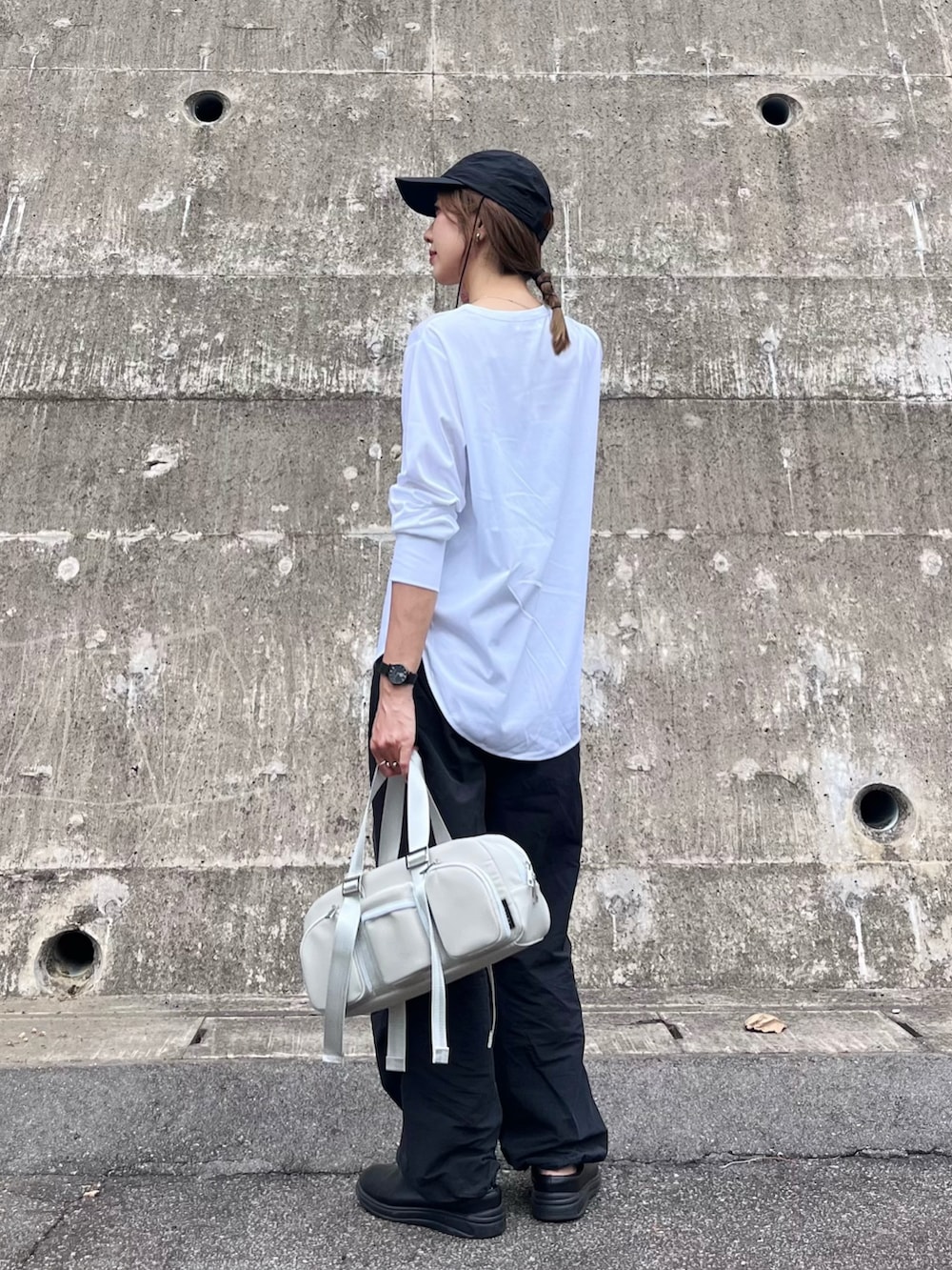ホワイト系のTシャツ/カットソー、グレー系のハンドバッグ、ブラック系のカーゴパンツを着用したレディースの秋コーディネートの2枚目の写真