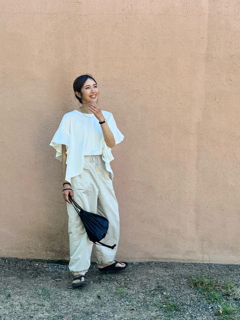 ホワイト系のTシャツ/カットソー、ブラック系のサンダル、ブラック系のショルダーバッグを着用したレディースの春コーディネートの2枚目の写真