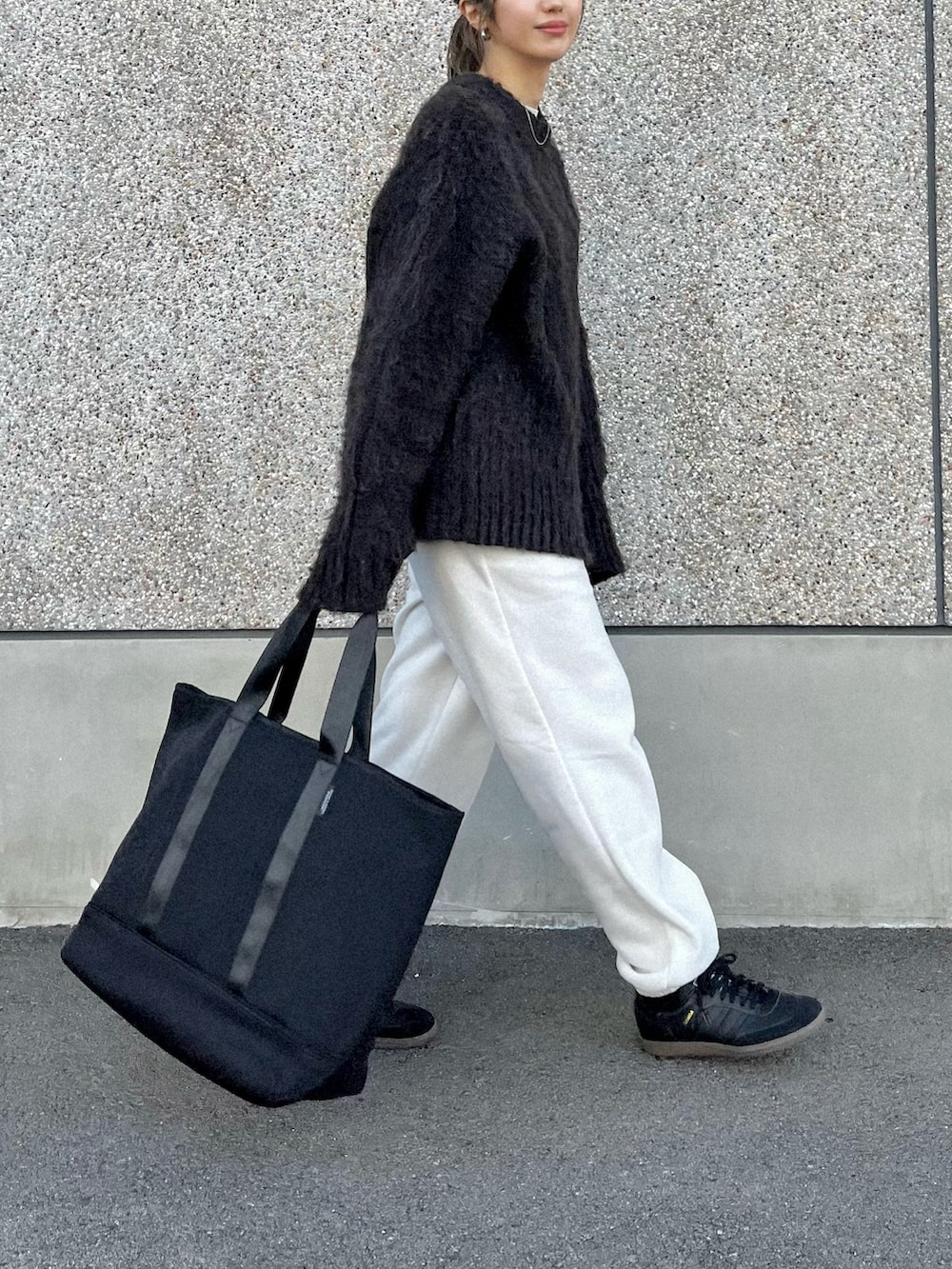 ブラック系のトートバッグ、ブラウン系のカーディガン/ボレロ、ブラック系のスニーカーを着用したレディースの冬コーディネートの2枚目の写真