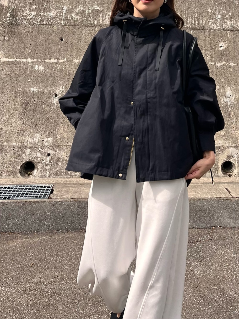 ブラック系のマウンテンパーカー、ホワイト系のその他パンツ、ブラック系のパンプスを着用したレディースの春コーディネートの3枚目の写真