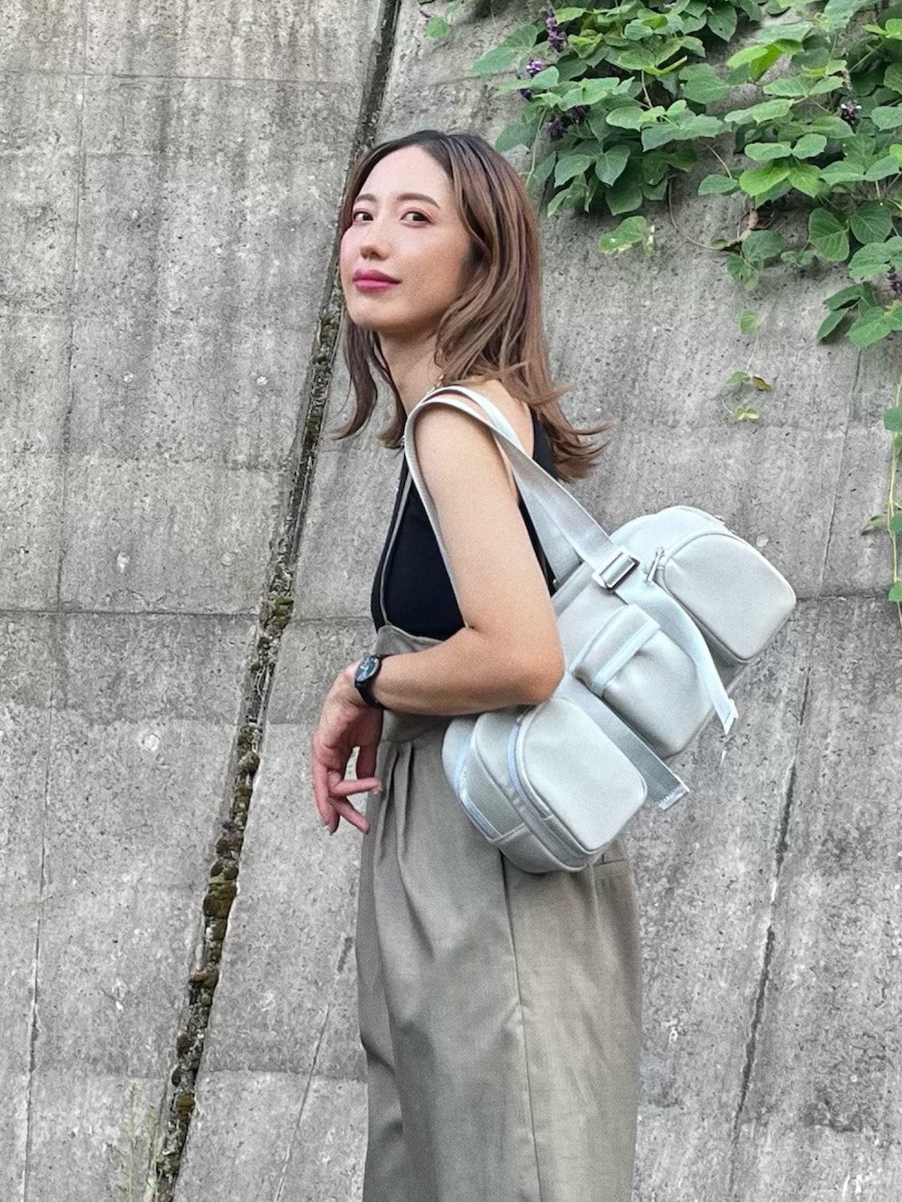 グレー系のサロペット/オーバーオール、グレー系のハンドバッグを着用したレディースの秋コーディネートの2枚目の写真