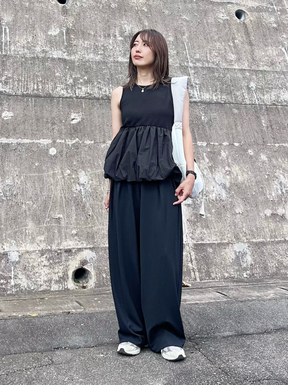 ブラック系のアンサンブル、ホワイト系のボディバッグ/ウエストポーチ、ピンク系の口紅/リップティント/グロスを着用したレディースの秋コーディネートの4枚目の写真