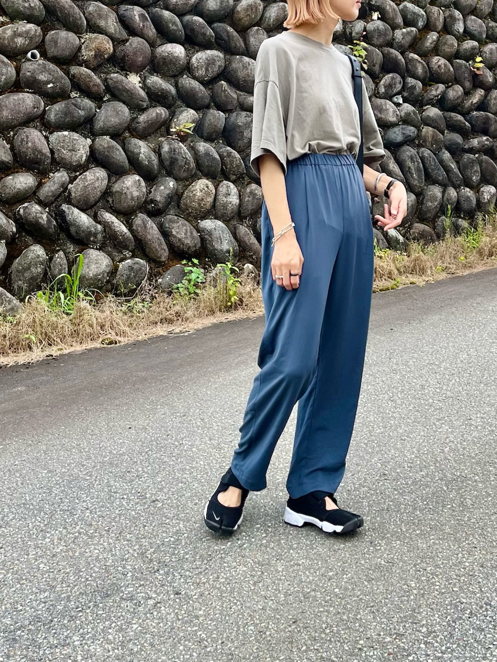 ブラック系のスニーカー、グレー系のその他パンツ、ブラック系のボディバッグ/ウエストポーチを着用したレディースの夏コーディネートの2枚目の写真