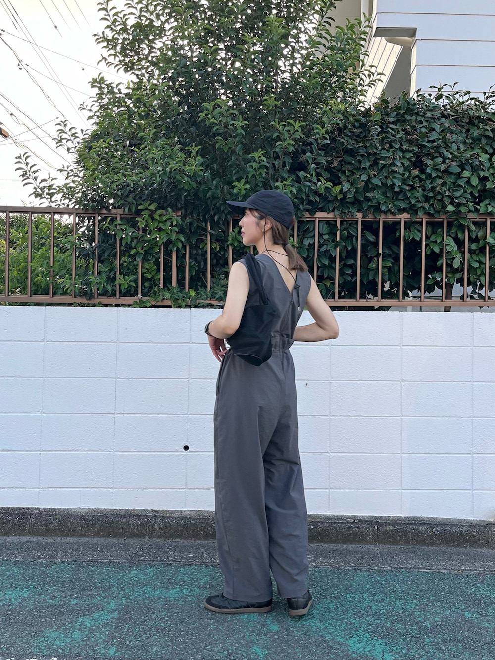 グレー系のつなぎ/オールインワン、ブラック系のスニーカー、ブラック系のキャップを着用したレディースの夏コーディネートの3枚目の写真