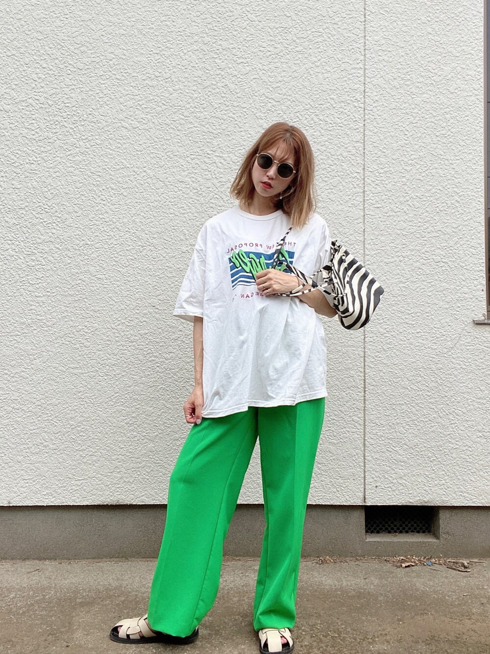 ホワイト系のTシャツ/カットソー、グリーン系のパンツ、ホワイト系のサンダルを着用したレディースの夏コーディネートの3枚目の写真