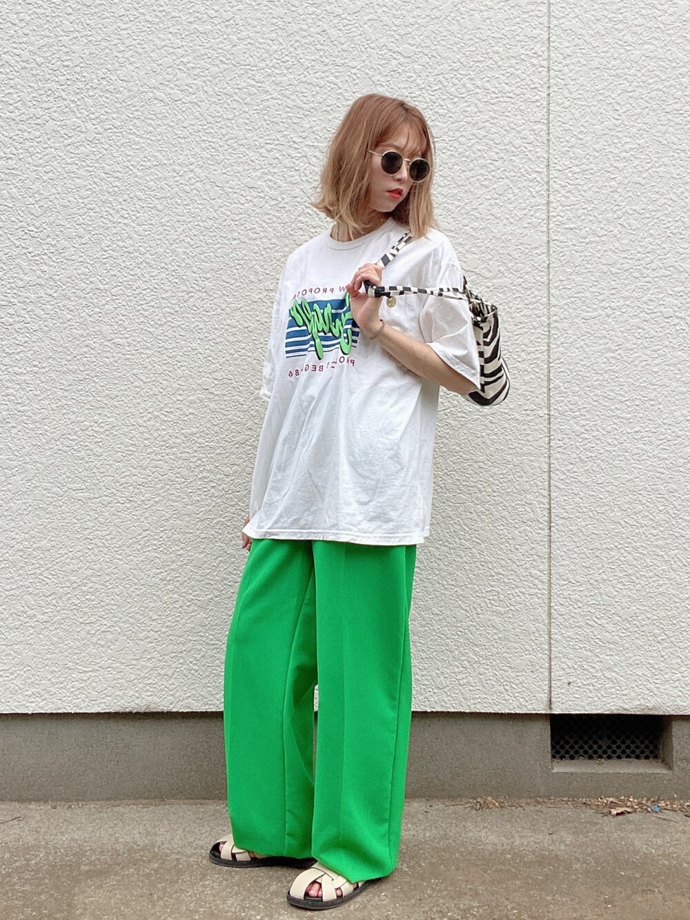 ホワイト系のTシャツ/カットソー、グリーン系のパンツ、ホワイト系のサンダルを着用したレディースの夏コーディネートの2枚目の写真