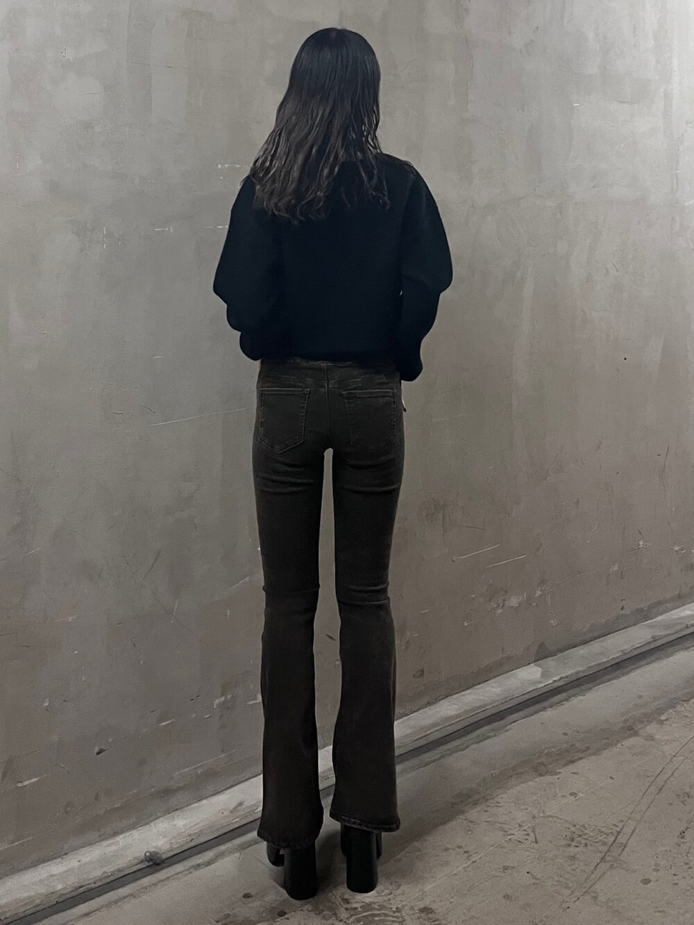 ブラック系のニット/セーター、ブラック系のデニムパンツ、ブラウン系のブーツを着用したレディースの秋コーディネートの3枚目の写真