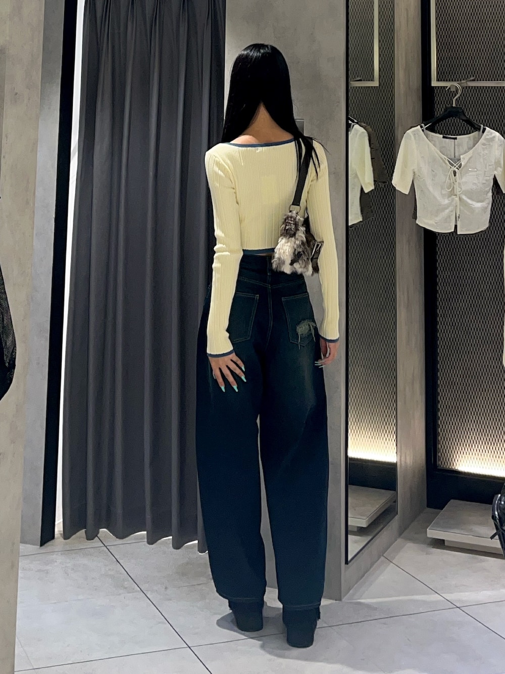 ホワイト系のニット/セーター、ブルー系のデニムパンツ、ブラック系のスリッポンを着用したレディースの秋コーディネートの3枚目の写真