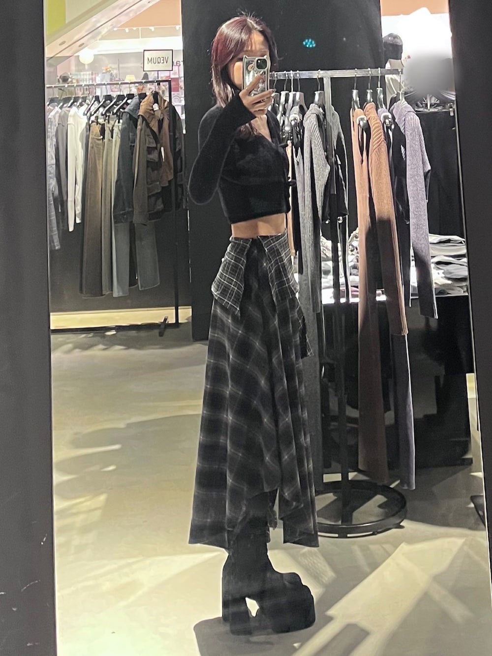 ブラック系のニット/セーター、ブラック系のスカート、ブラック系のブーツを着用したレディースの秋コーディネートの2枚目の写真