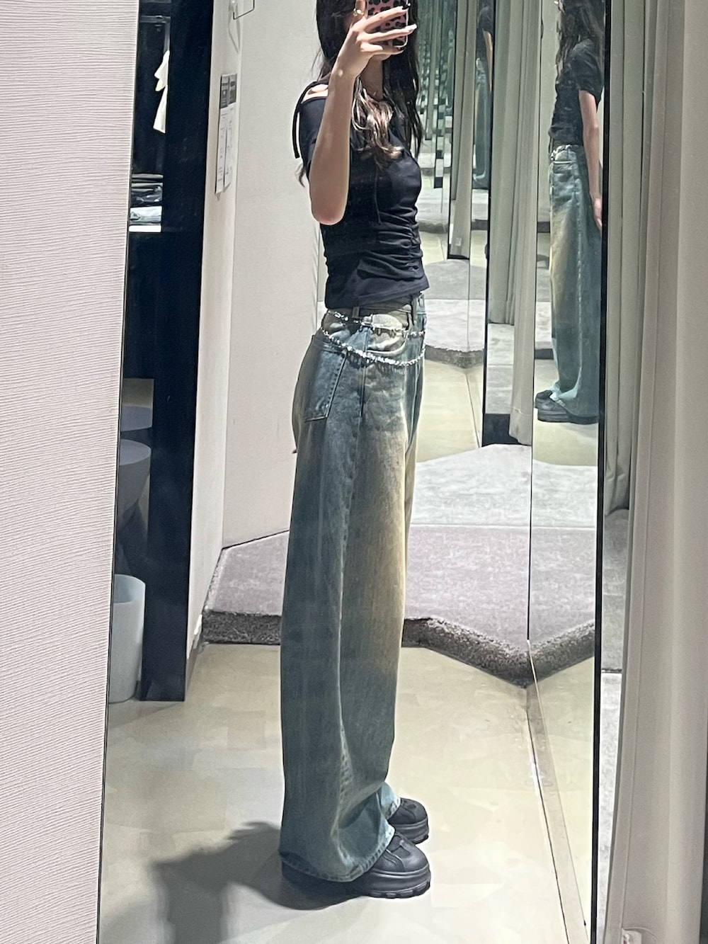 ブラック系のTシャツ/カットソー、ブルー系のデニムパンツ、ブラック系のサンダルを着用したレディースの春コーディネートの2枚目の写真