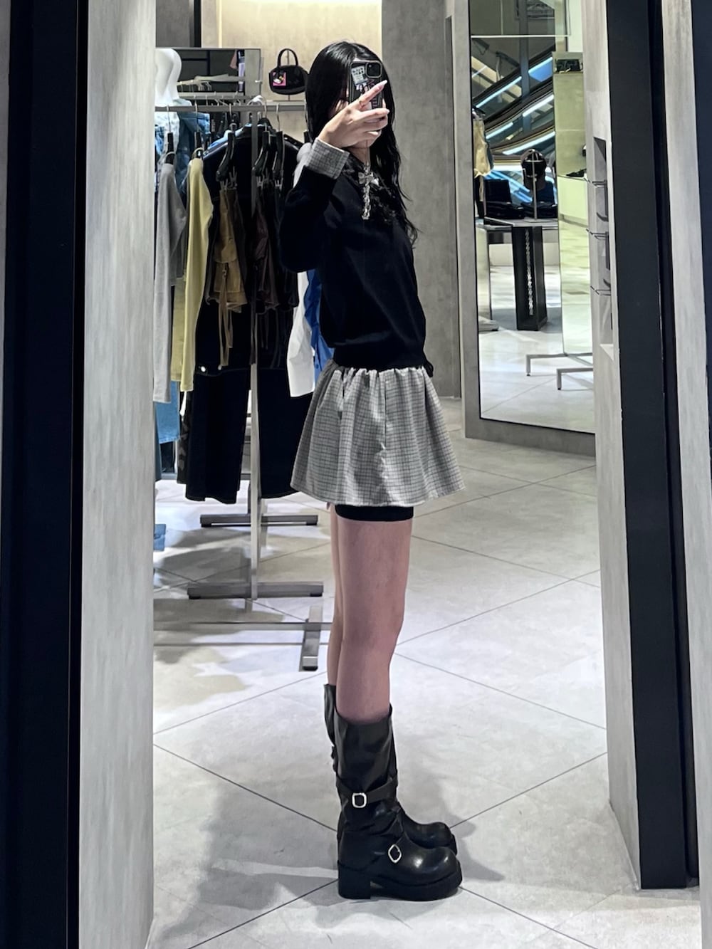 ブラック系のシャツ/ブラウス、ブラック系のスカート、ブラック系のブーツを着用したレディースの春コーディネートの2枚目の写真