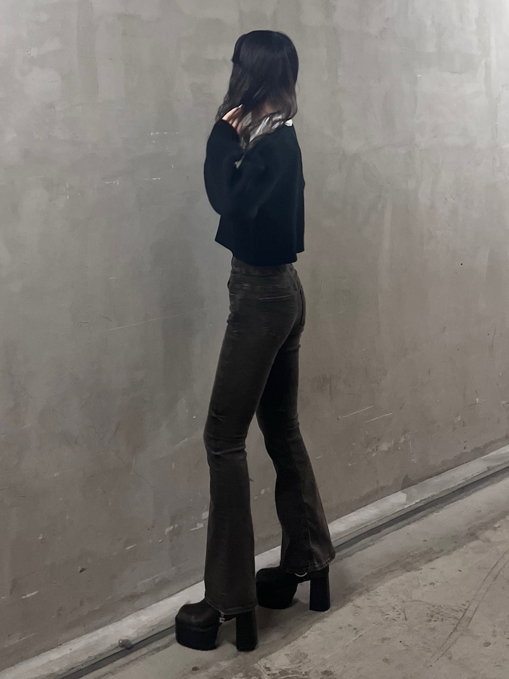 ブラック系のニット/セーター、ブラック系のデニムパンツ、ブラウン系のブーツを着用したレディースの秋コーディネートの2枚目の写真