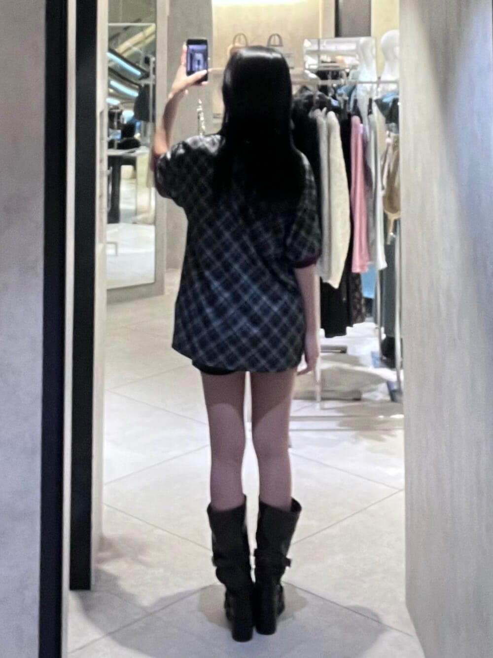 ブラック系のブーツ、ブラック系のTシャツ/カットソー、ブラック系のスカートを着用したレディースの春コーディネートの3枚目の写真