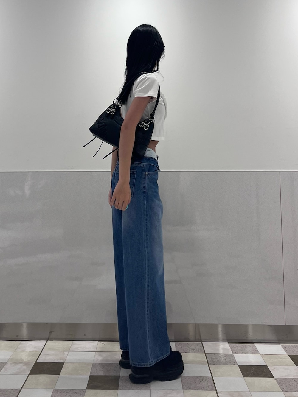 ホワイト系のTシャツ/カットソー、ブルー系のデニムパンツ、ブラック系のスニーカーを着用したレディースの夏コーディネートの2枚目の写真