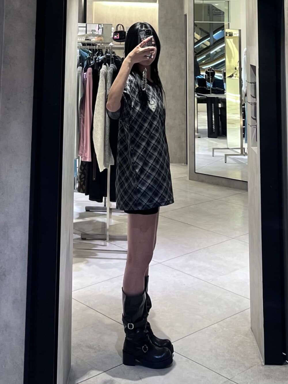 ブラック系のブーツ、ブラック系のTシャツ/カットソー、ブラック系のスカートを着用したレディースの春コーディネートの2枚目の写真