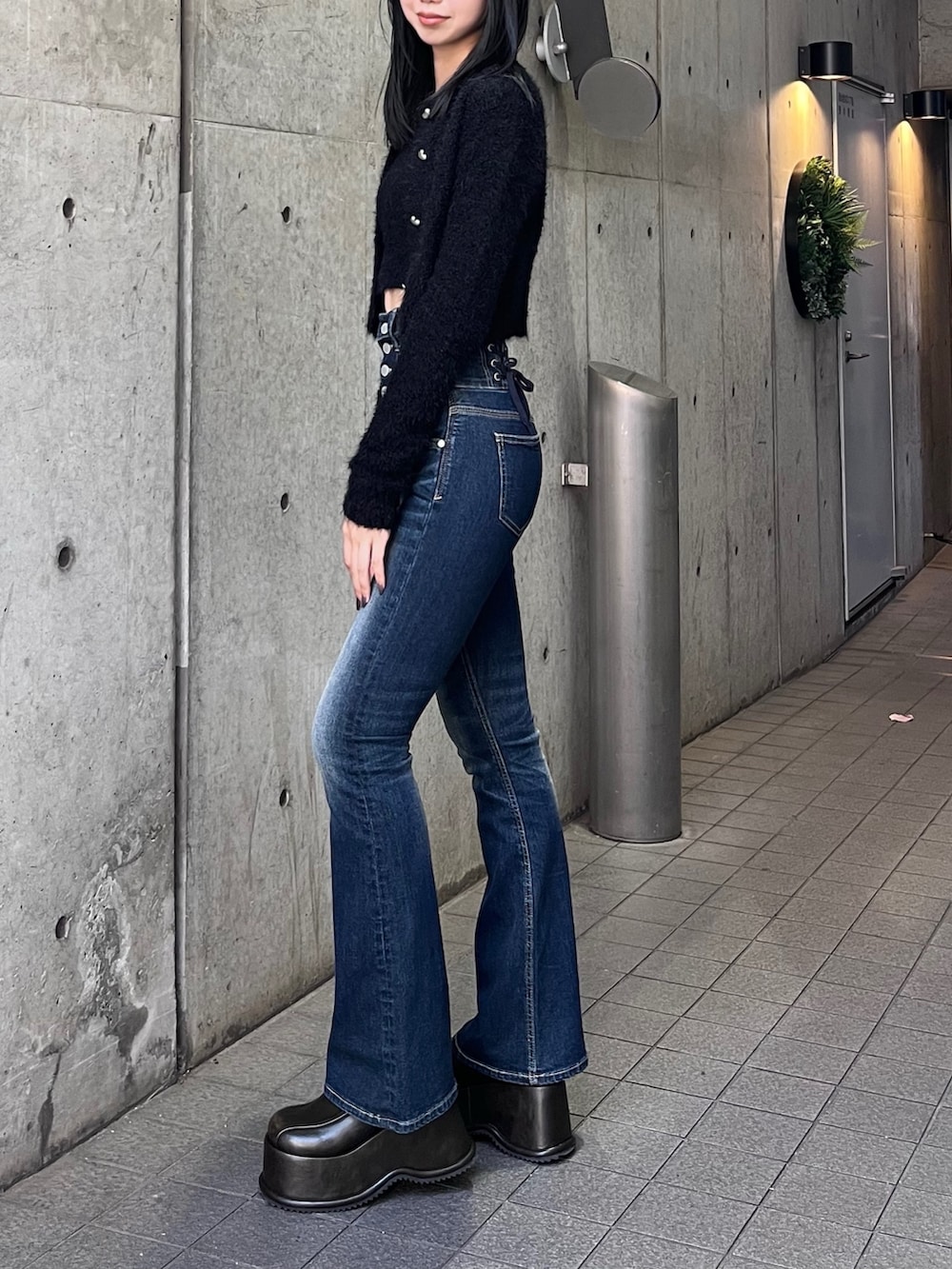ブラック系のニット/セーター、ブルー系のデニムパンツ、その他のローファーを着用したレディースの秋コーディネートの2枚目の写真