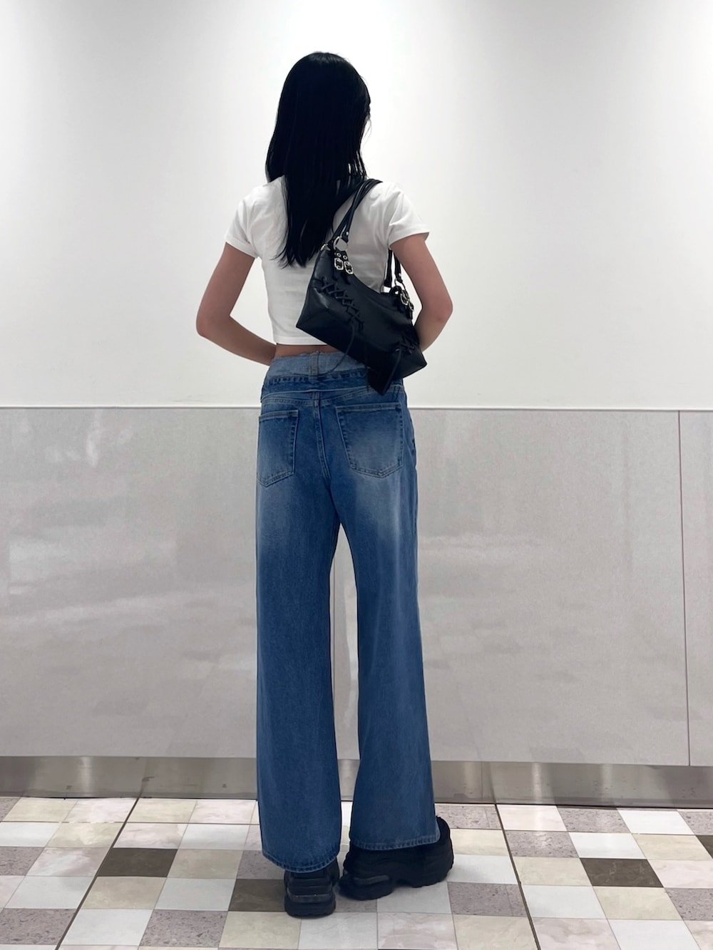 ホワイト系のTシャツ/カットソー、ブルー系のデニムパンツ、ブラック系のスニーカーを着用したレディースの夏コーディネートの3枚目の写真