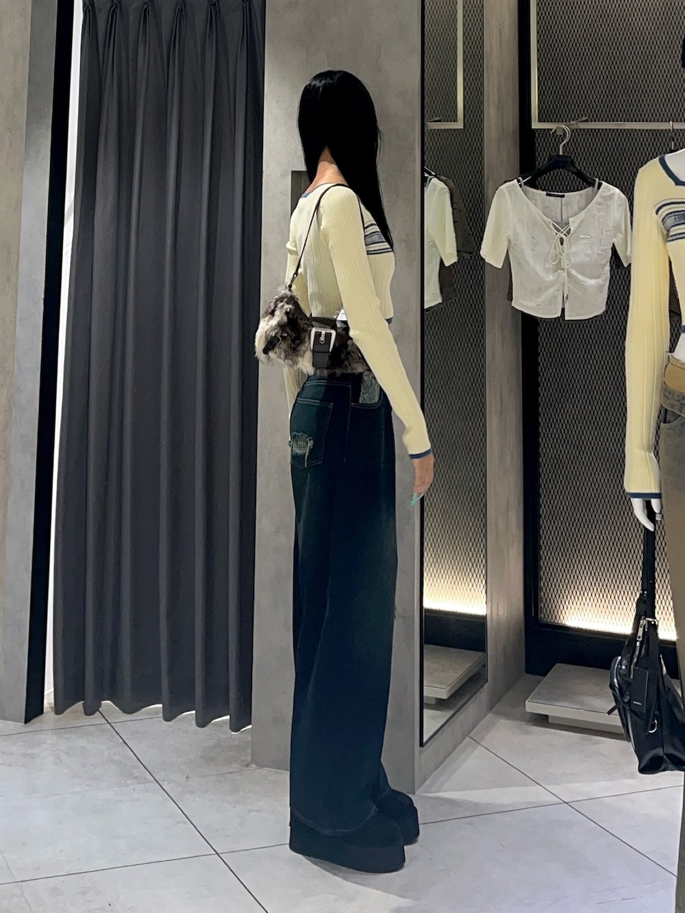ホワイト系のニット/セーター、ブルー系のデニムパンツ、ブラック系のスリッポンを着用したレディースの秋コーディネートの2枚目の写真