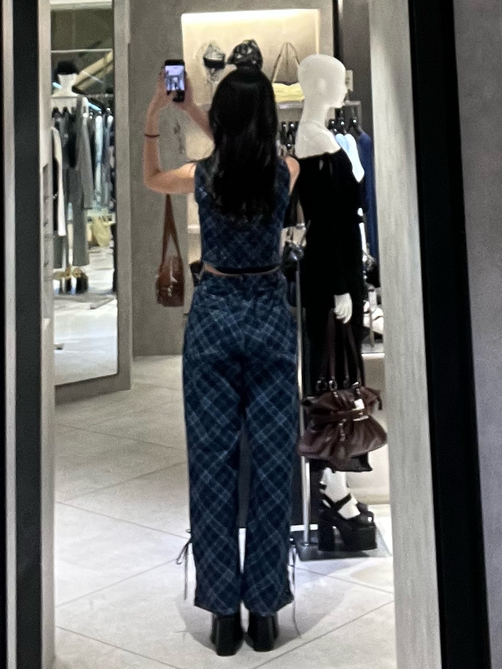 ブルー系のタンクトップ、ブルー系のデニムパンツ、ブラック系のサンダルを着用したレディースの春コーディネートの3枚目の写真