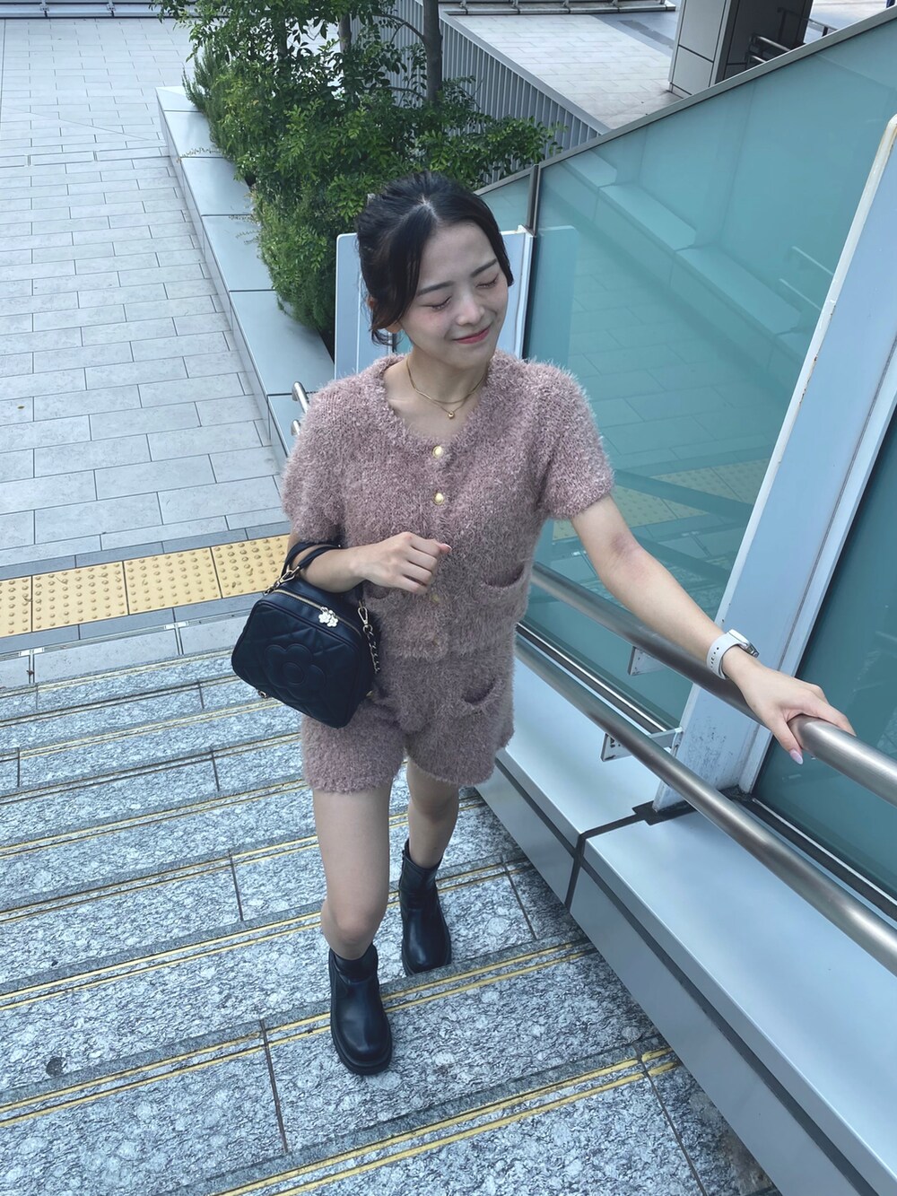 ブラック系のショルダーバッグ、ピンク系のカーディガン/ボレロを着用したレディースの秋コーディネートの2枚目の写真