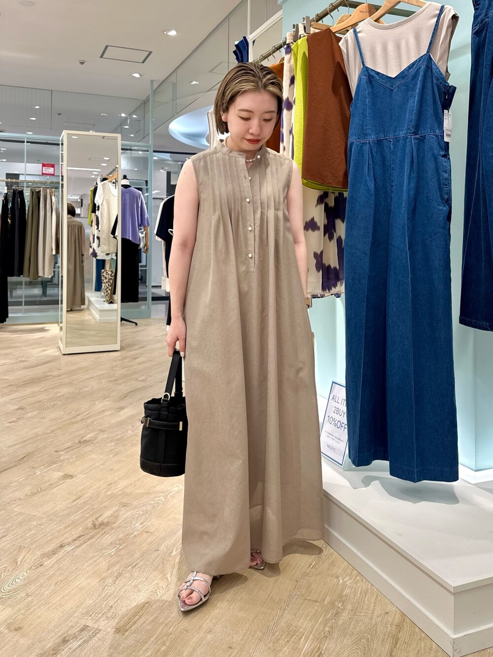 ブラウン系のシャツワンピース、ブラック系のショルダーバッグを着用したレディースの夏コーディネートの6枚目の写真