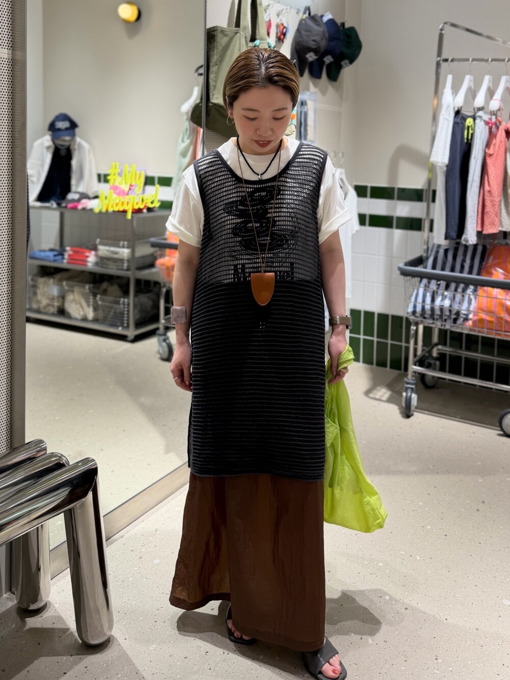 ホワイト系のTシャツ/カットソー、グレー系のニット/セーター、ブラウン系のスカートを着用したレディースの春コーディネートの8枚目の写真