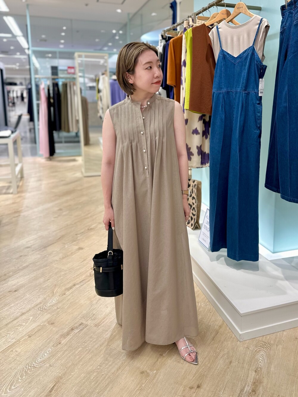 ブラウン系のシャツワンピース、ブラック系のショルダーバッグを着用したレディースの夏コーディネートの7枚目の写真