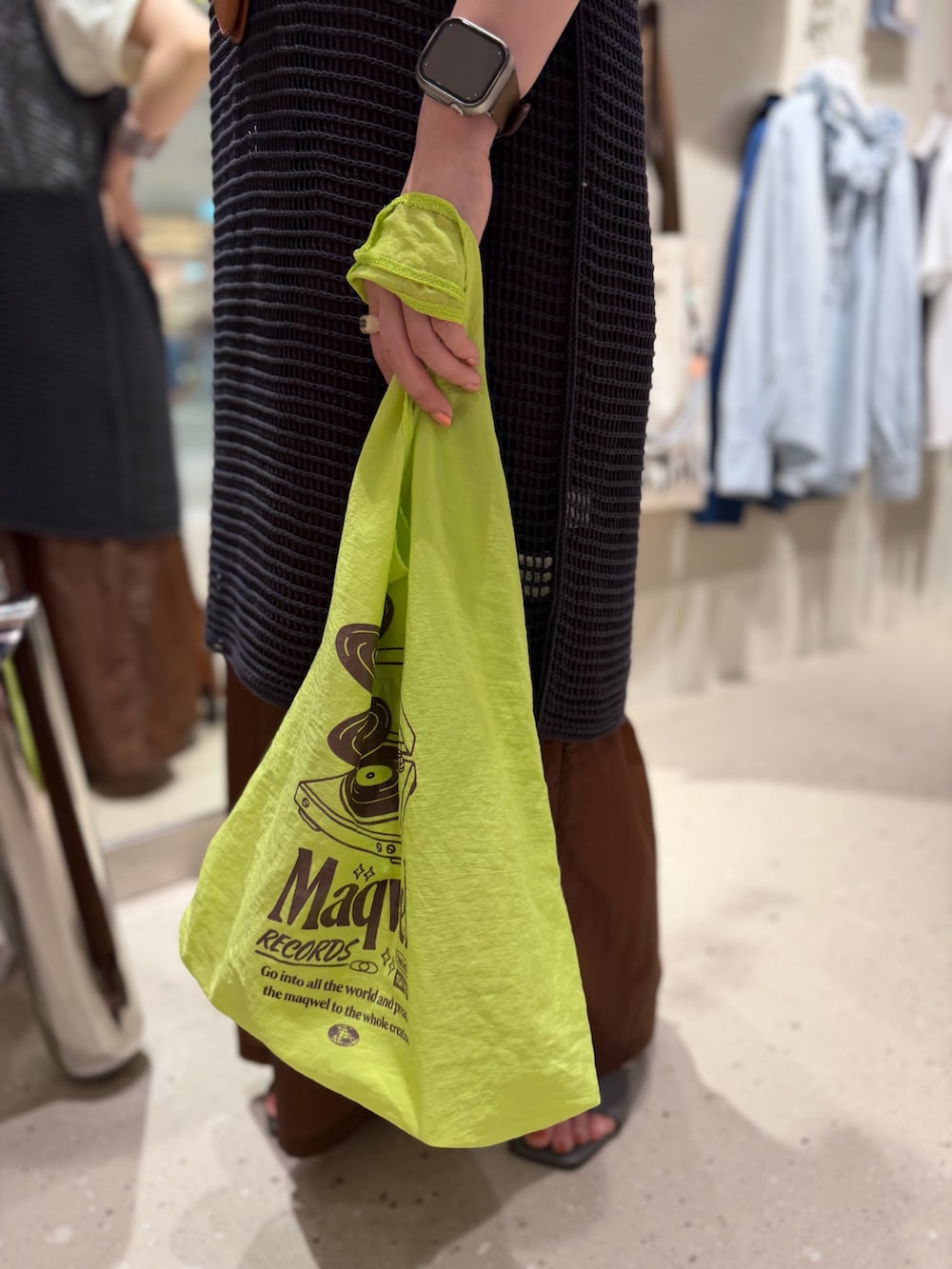 ホワイト系のTシャツ/カットソー、グレー系のニット/セーター、ブラウン系のスカートを着用したレディースの春コーディネートの7枚目の写真