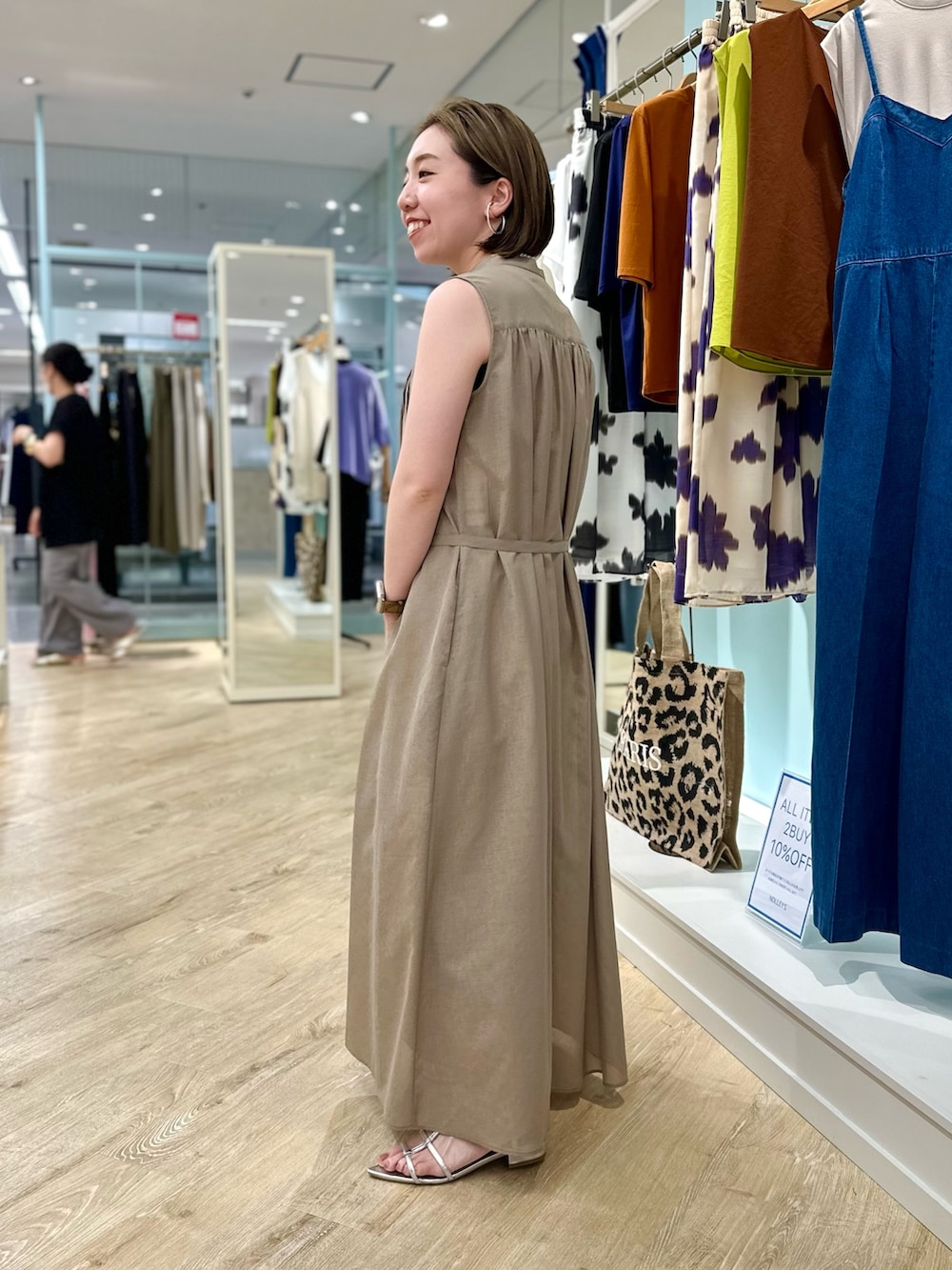 ブラウン系のシャツワンピース、ブラック系のショルダーバッグを着用したレディースの夏コーディネートの4枚目の写真