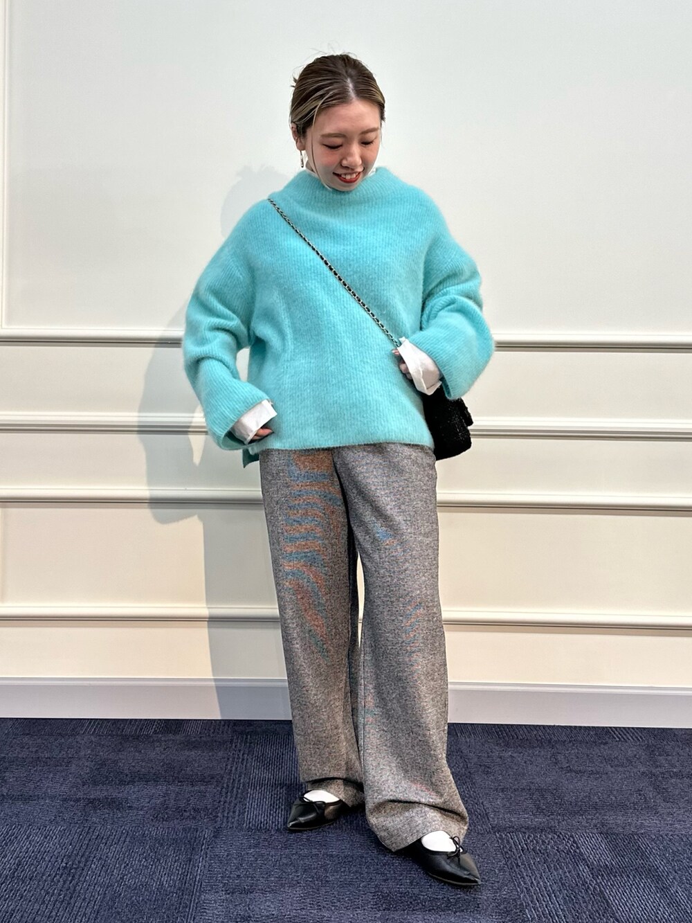 グリーン系のニット/セーター、シルバー系のTシャツ/カットソー、グレー系のその他パンツを着用したレディースの冬コーディネートの2枚目の写真