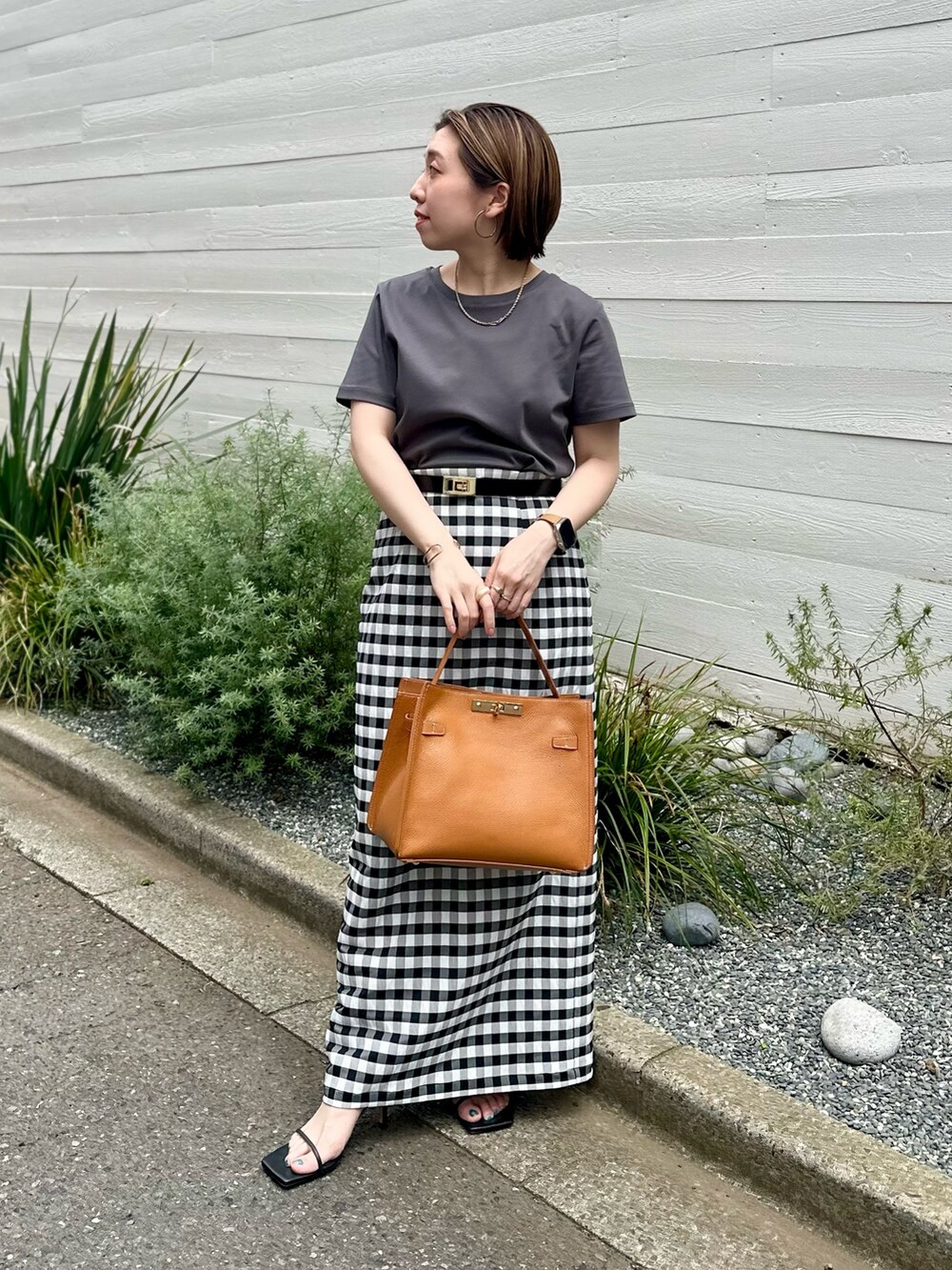 グレー系のTシャツ/カットソー、ホワイト系のテーラードジャケット、ブラック系のスカートを着用したレディースの夏コーディネートの5枚目の写真