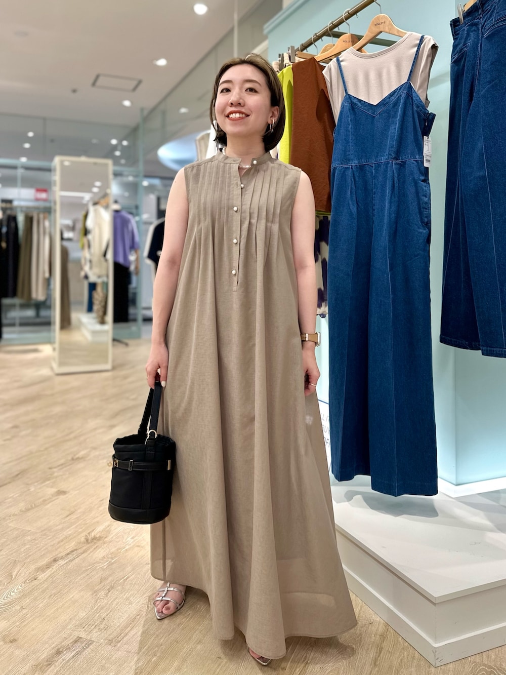 ブラウン系のシャツワンピース、ブラック系のショルダーバッグを着用したレディースの夏コーディネートの2枚目の写真