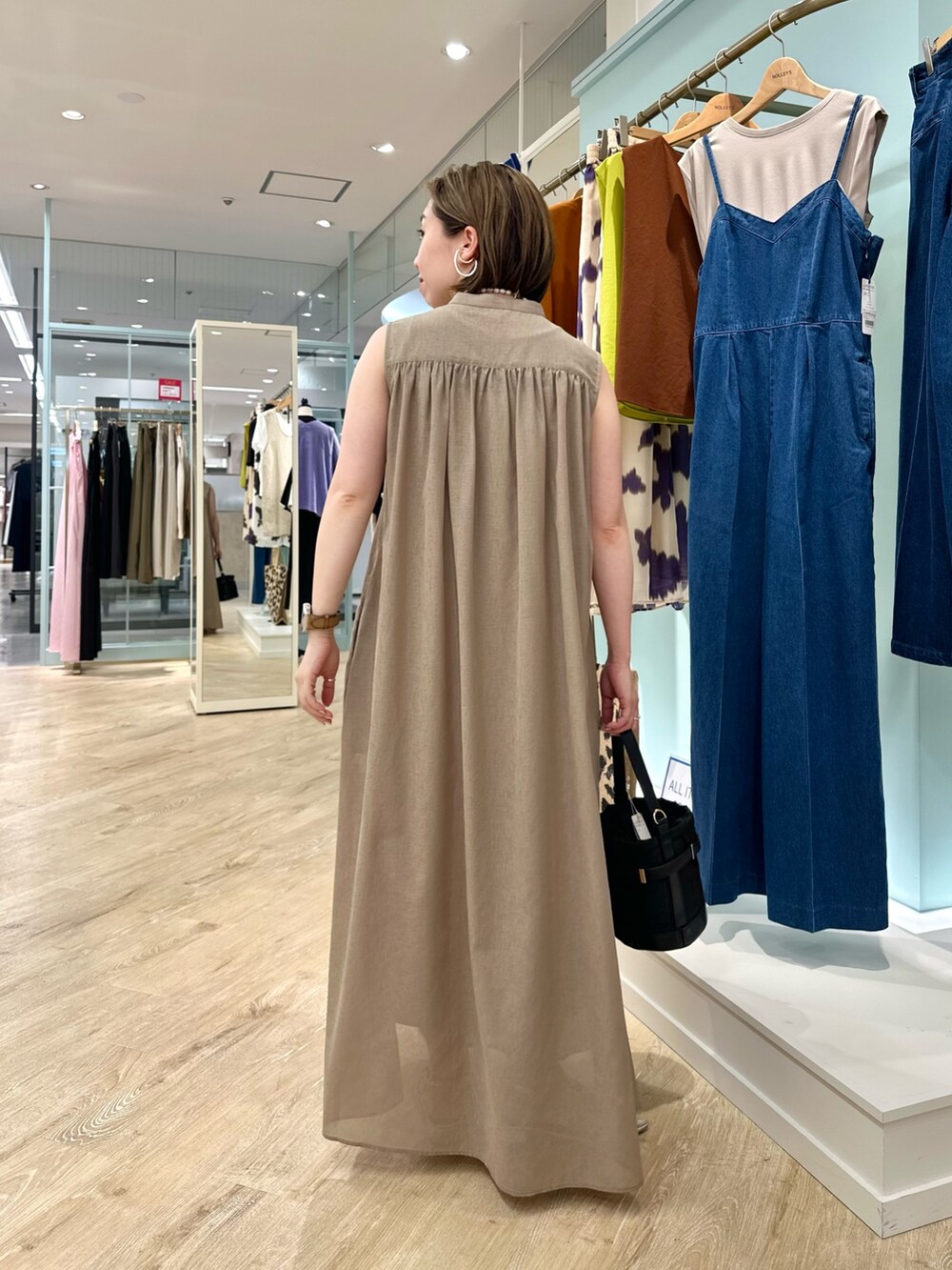 ブラウン系のシャツワンピース、ブラック系のショルダーバッグを着用したレディースの夏コーディネートの5枚目の写真