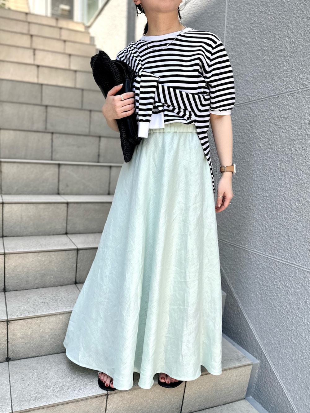 グリーン系のスカート、ブラック系のニット/セーター、ブラック系のカーディガン/ボレロを着用したレディースの夏コーディネートの9枚目の写真