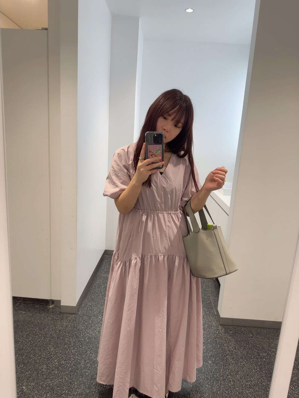 ピンク系のワンピース、グレー系のハンドバッグ、ホワイト系のパンプスを着用したレディースの夏コーディネートの2枚目の写真