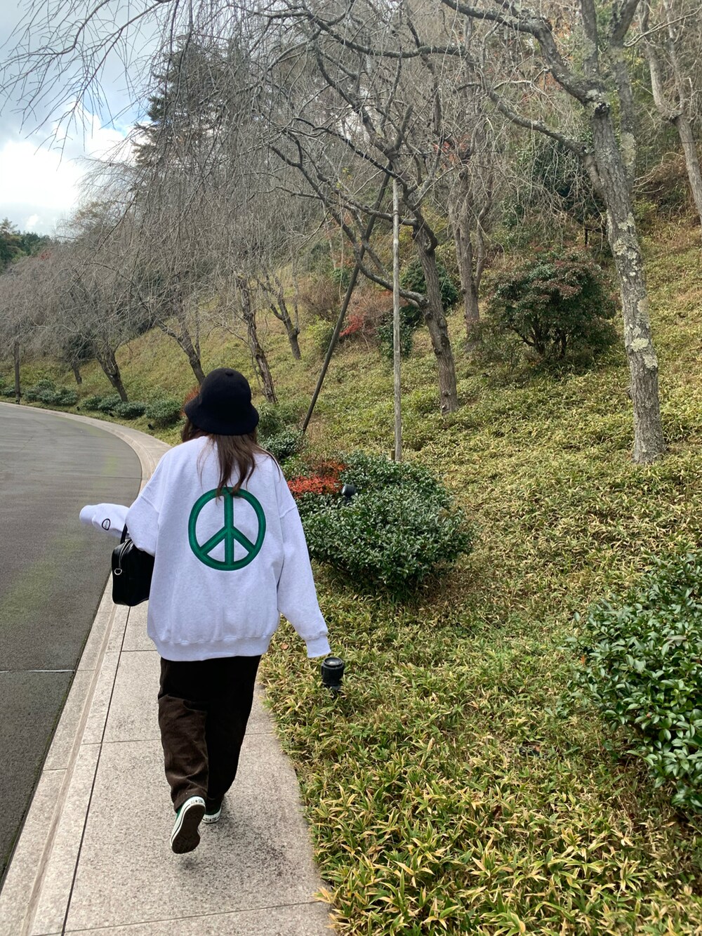 グレー系のスウェット、ブラウン系のその他パンツ、グリーン系のスニーカーを着用したレディースの冬コーディネートの2枚目の写真