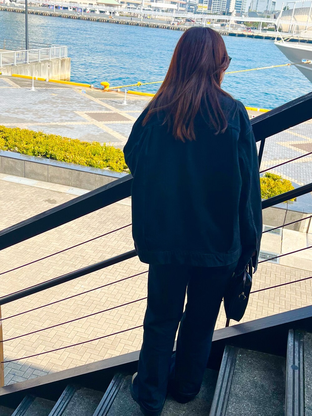 ブラック系のデニムジャケット、ブルー系のデニムパンツ、ブラック系のブーツを着用したレディースの冬コーディネートの2枚目の写真