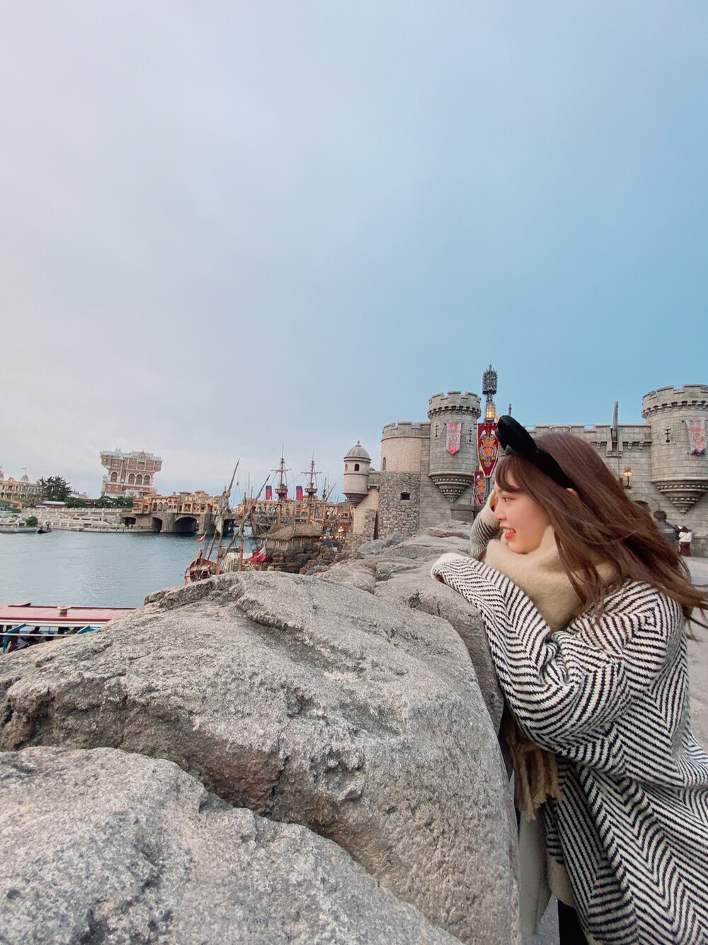 ブラック系のパンツ、ホワイト系のスニーカー、ベージュ系のマフラーを着用したレディースの冬コーディネートの2枚目の写真