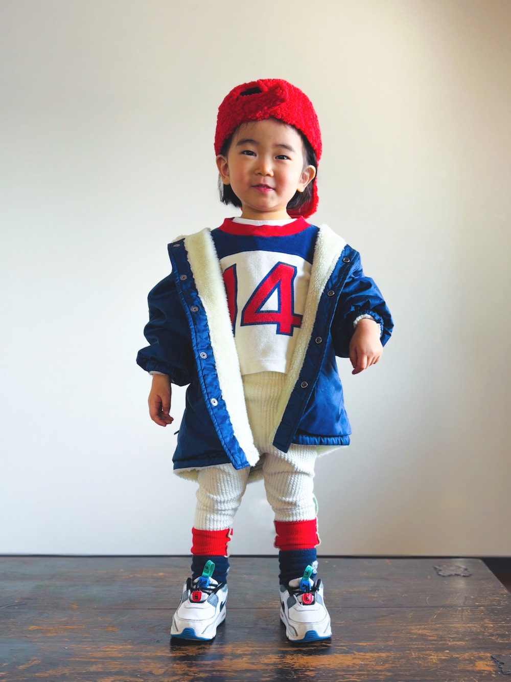 ブルー系のナイロンジャケット、ホワイト系のスニーカー、レッド系のTシャツ/カットソーを着用したキッズの冬コーディネートの3枚目の写真