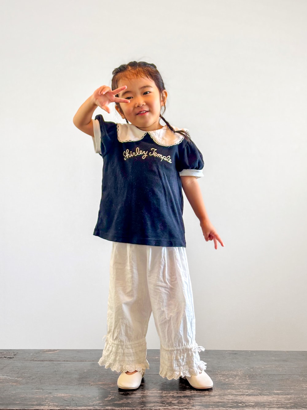 ホワイト系のその他パンツ、ブラック系のTシャツ/カットソー、ホワイト系のパンプスを着用したキッズの夏コーディネートの2枚目の写真