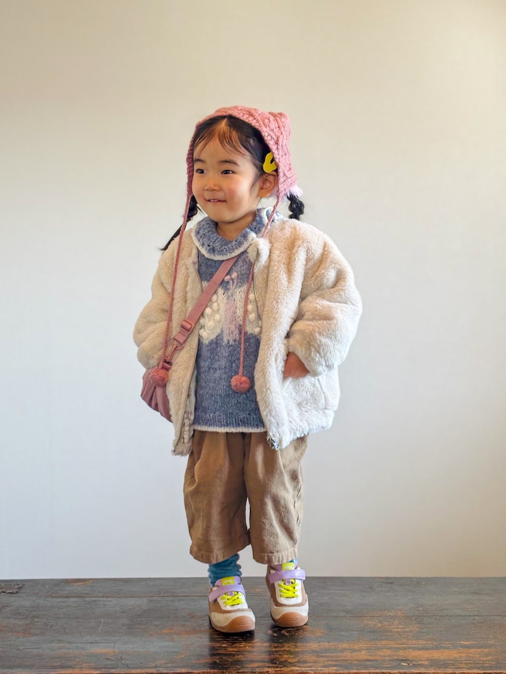 ベージュ系のブルゾン、ベージュ系のつなぎ/オールインワン、イエロー系のスニーカーを着用したキッズの冬コーディネートの3枚目の写真