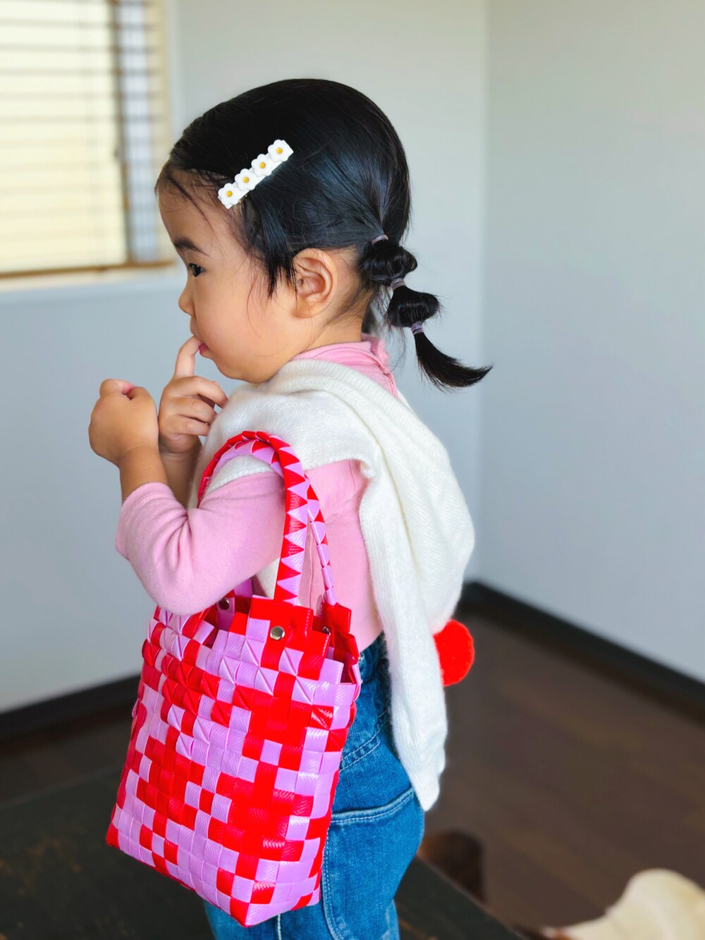 ブルー系のデニムパンツ、ホワイト系のスニーカー、ホワイト系のベストを着用したキッズの秋コーディネートの3枚目の写真