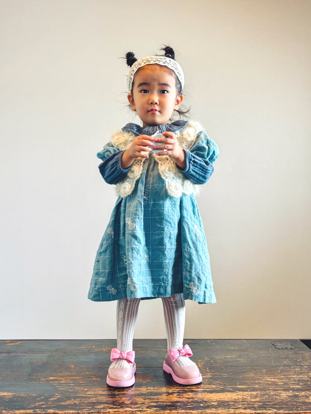 ホワイト系のカーディガン/ボレロ、グリーン系のシャツ/ブラウス、ブルー系のワンピースを着用したキッズの秋コーディネートの3枚目の写真