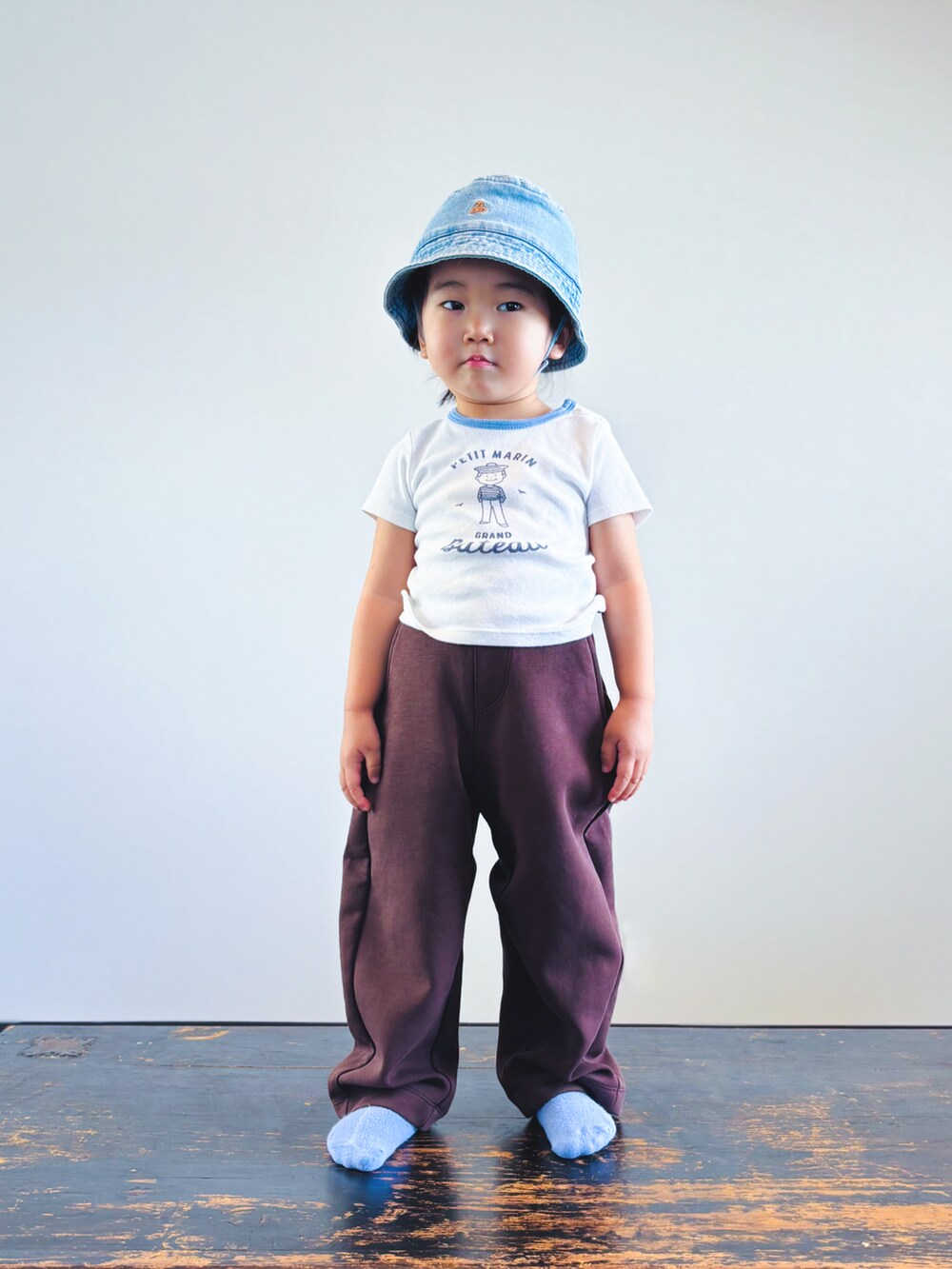 ホワイト系のTシャツ/カットソー、ブラウン系のスウェットパンツ、ブルー系のハットを着用したキッズの夏コーディネートの2枚目の写真