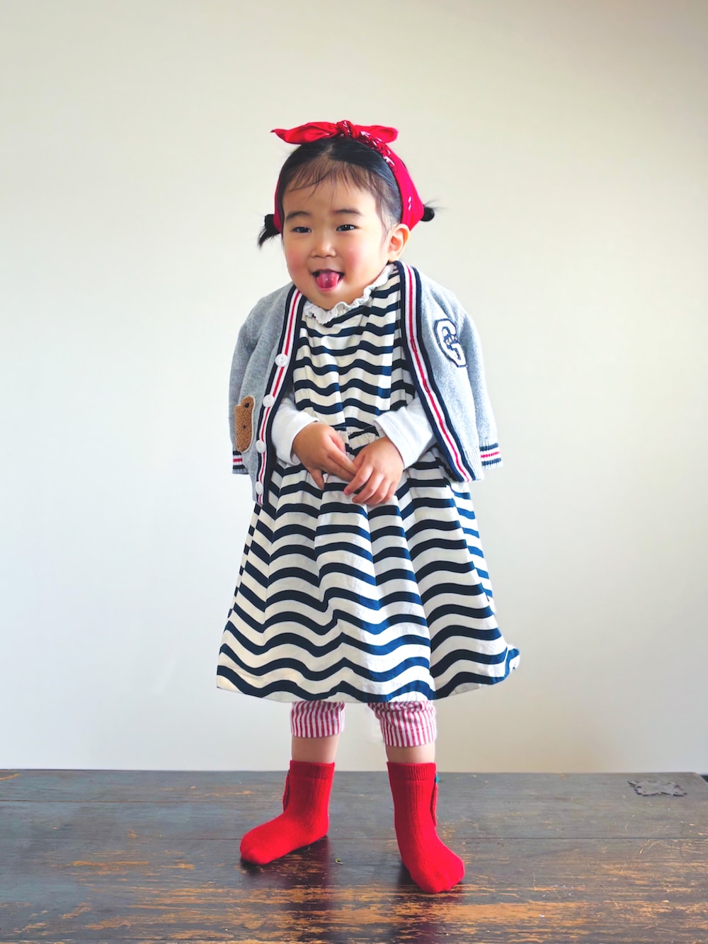 ブラック系のワンピース、ホワイト系のTシャツ/カットソー、グレー系のカーディガン/ボレロを着用したキッズの春コーディネートの3枚目の写真