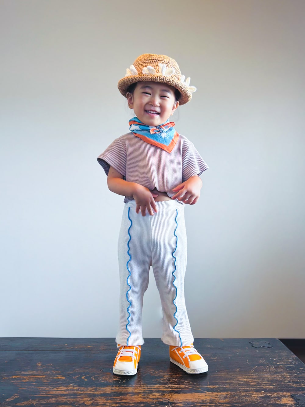 オレンジ系のスニーカー、ホワイト系のレギンス/スパッツ、その他のバンダナ/スカーフを着用したキッズの夏コーディネートの3枚目の写真